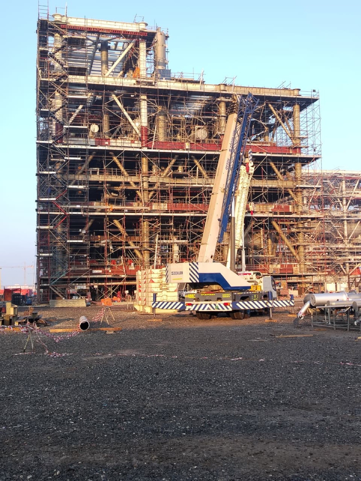 Multi-level process module under construction with crane